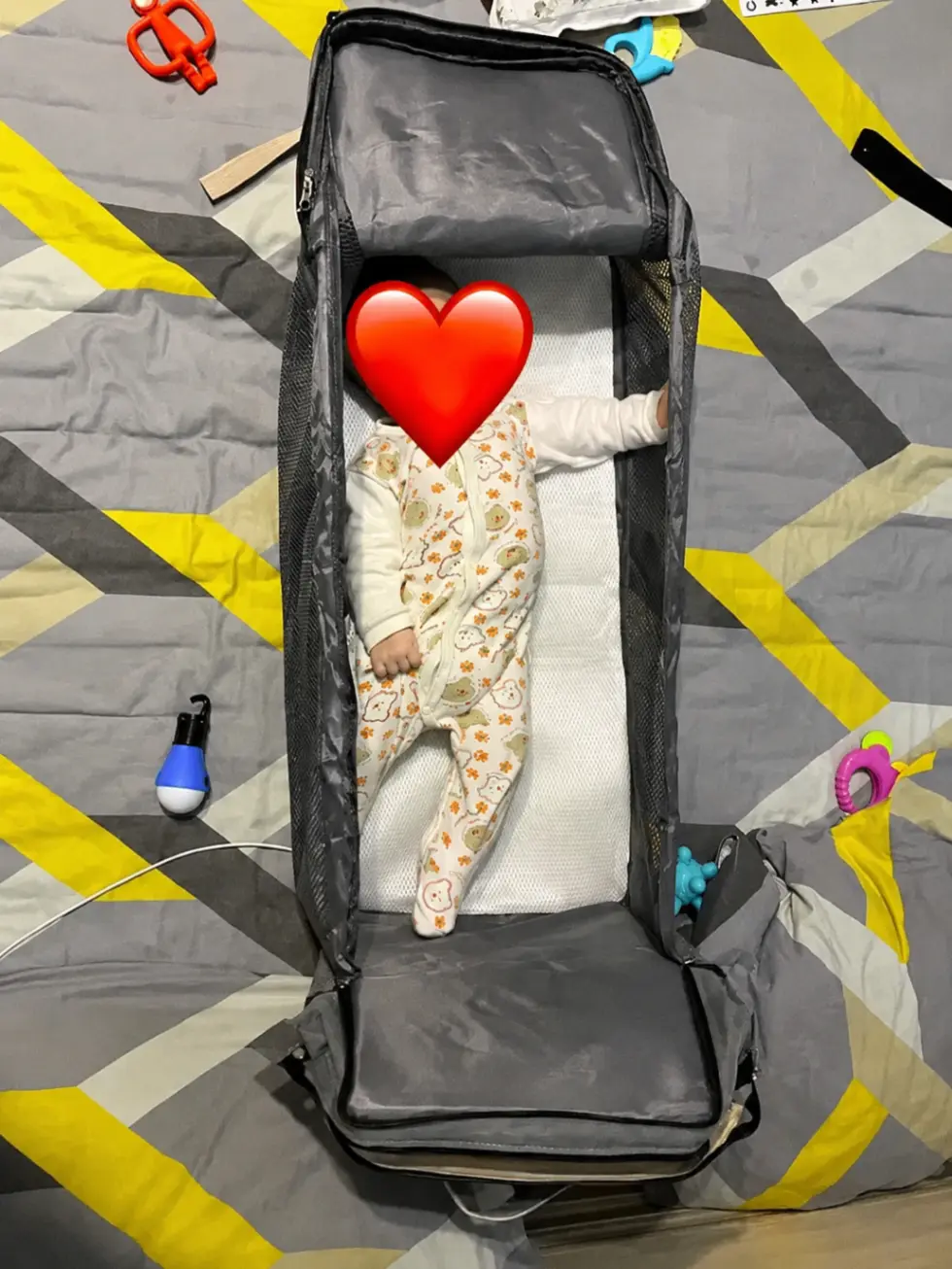 Reviewfoto van baby in het uitgeklapte bedgedeelte van de BabyGo Luiertas
